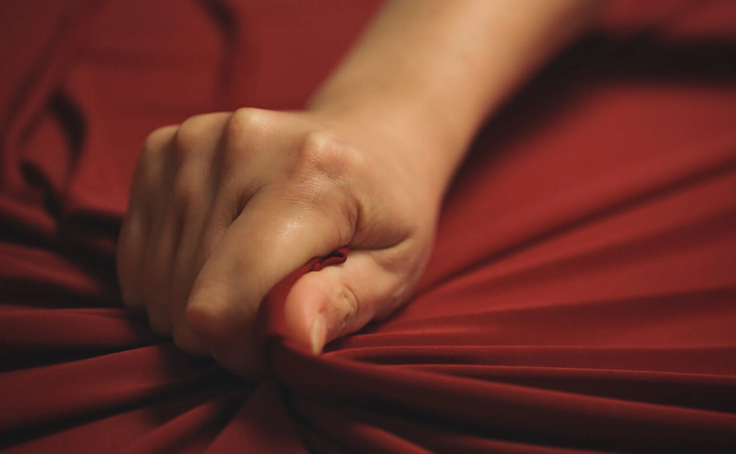 Orgasmus - weiblicher Orgasmus - Frau, die ein Leintuch drückt