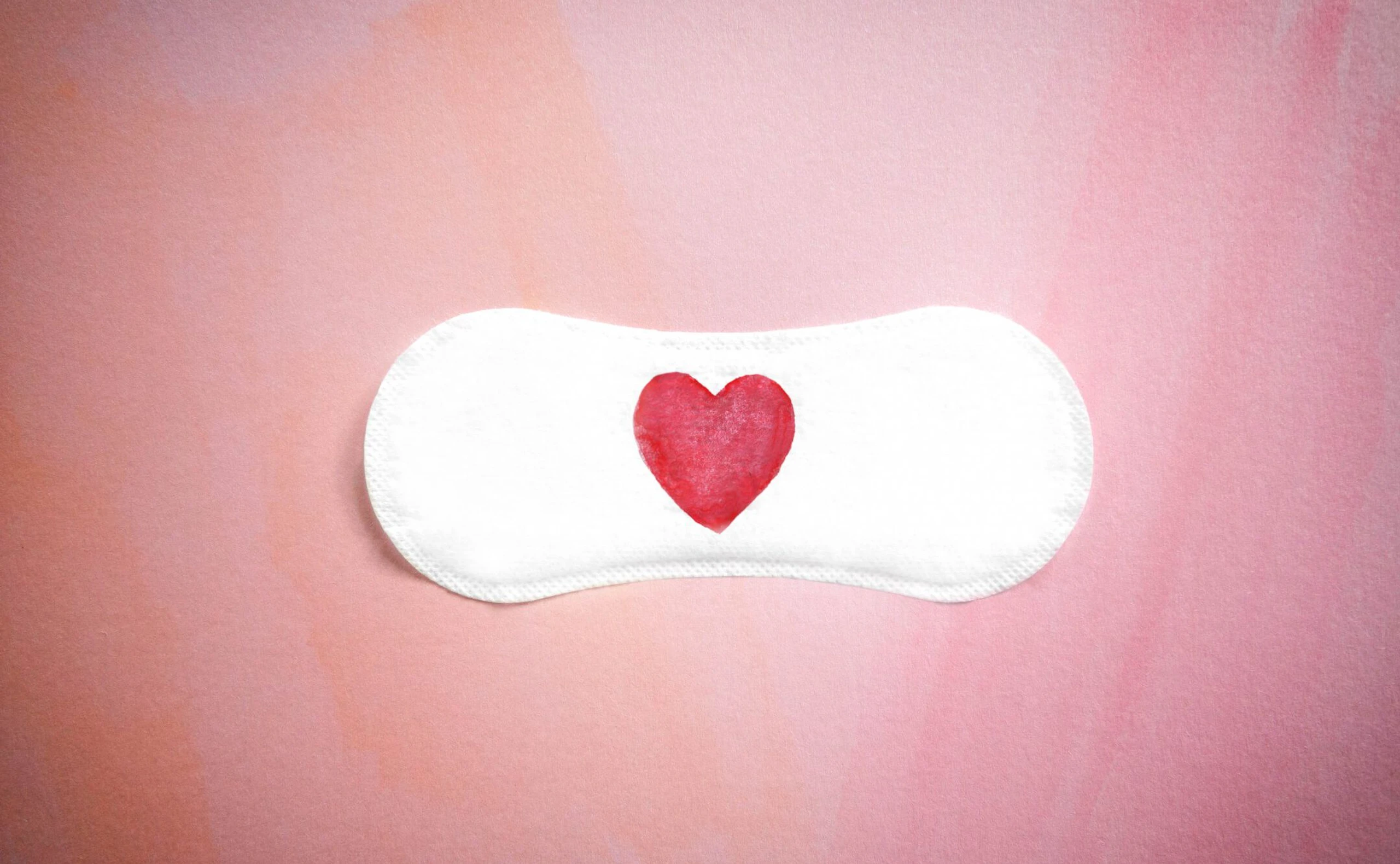 Damenbinde mit einem roten Herz auf einem rosa Hintergrund