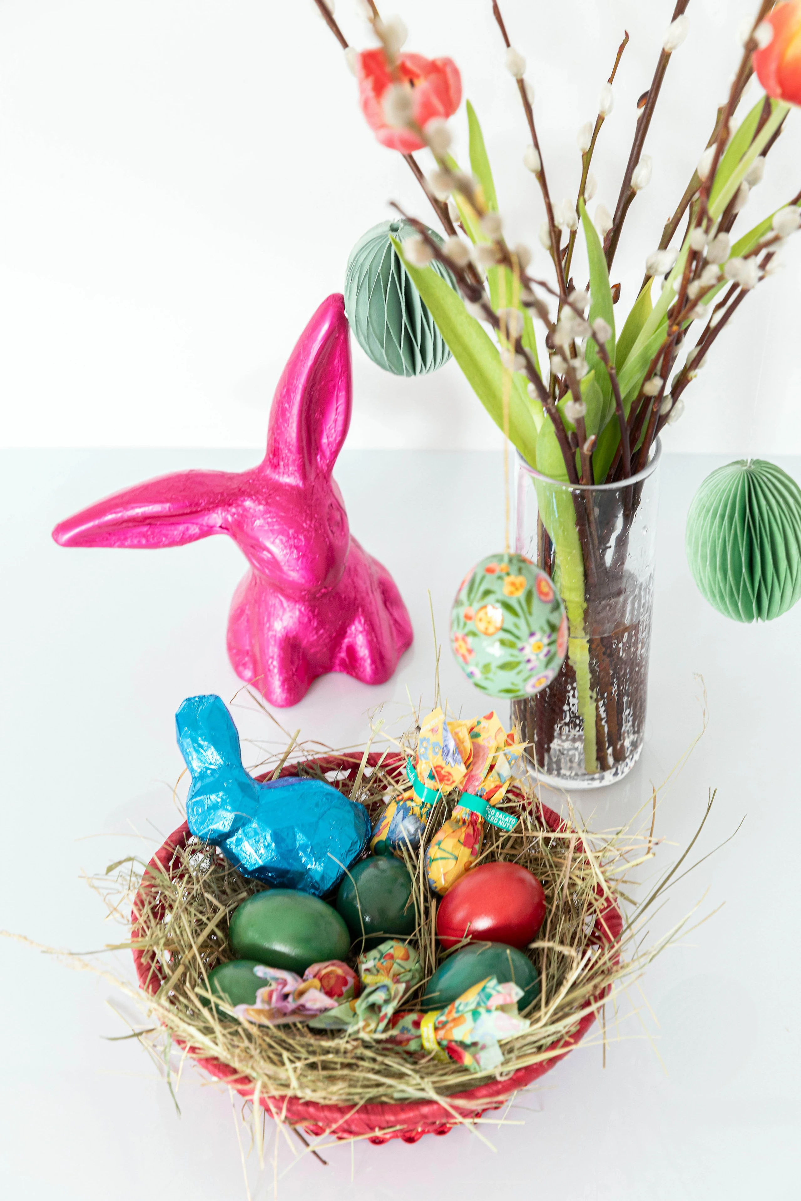 Befülltes Osternest und geschmückter Osterstrauch