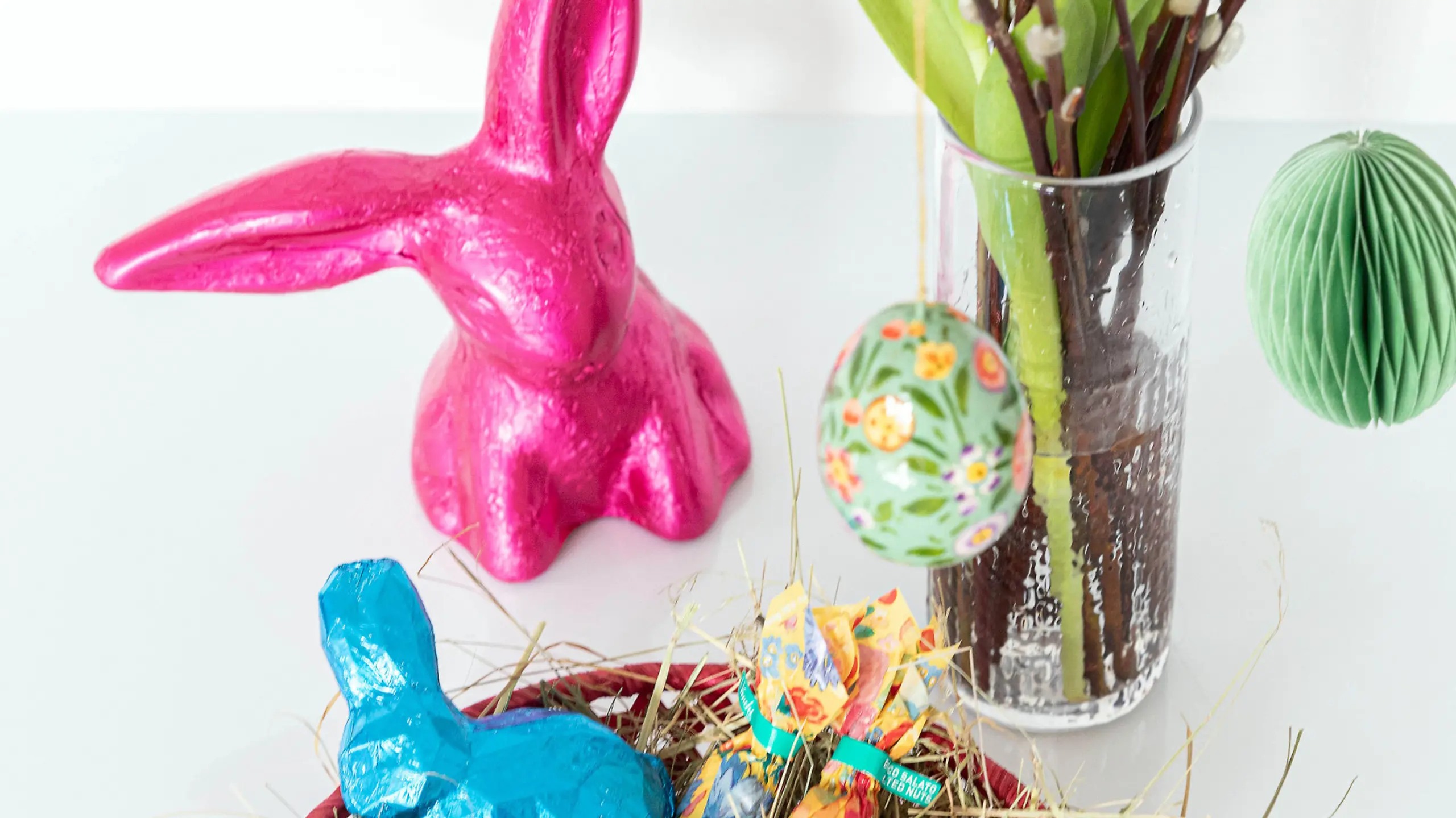 Befülltes Osternest und geschmückter Osterstrauch