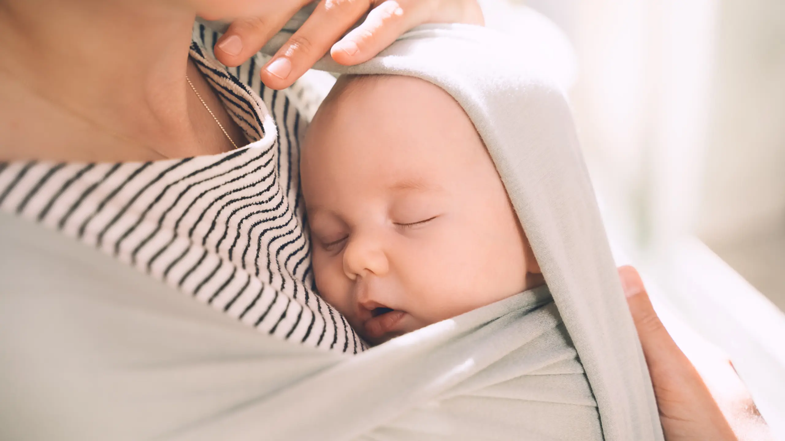 Baby, das in einem Tragetuch schläft