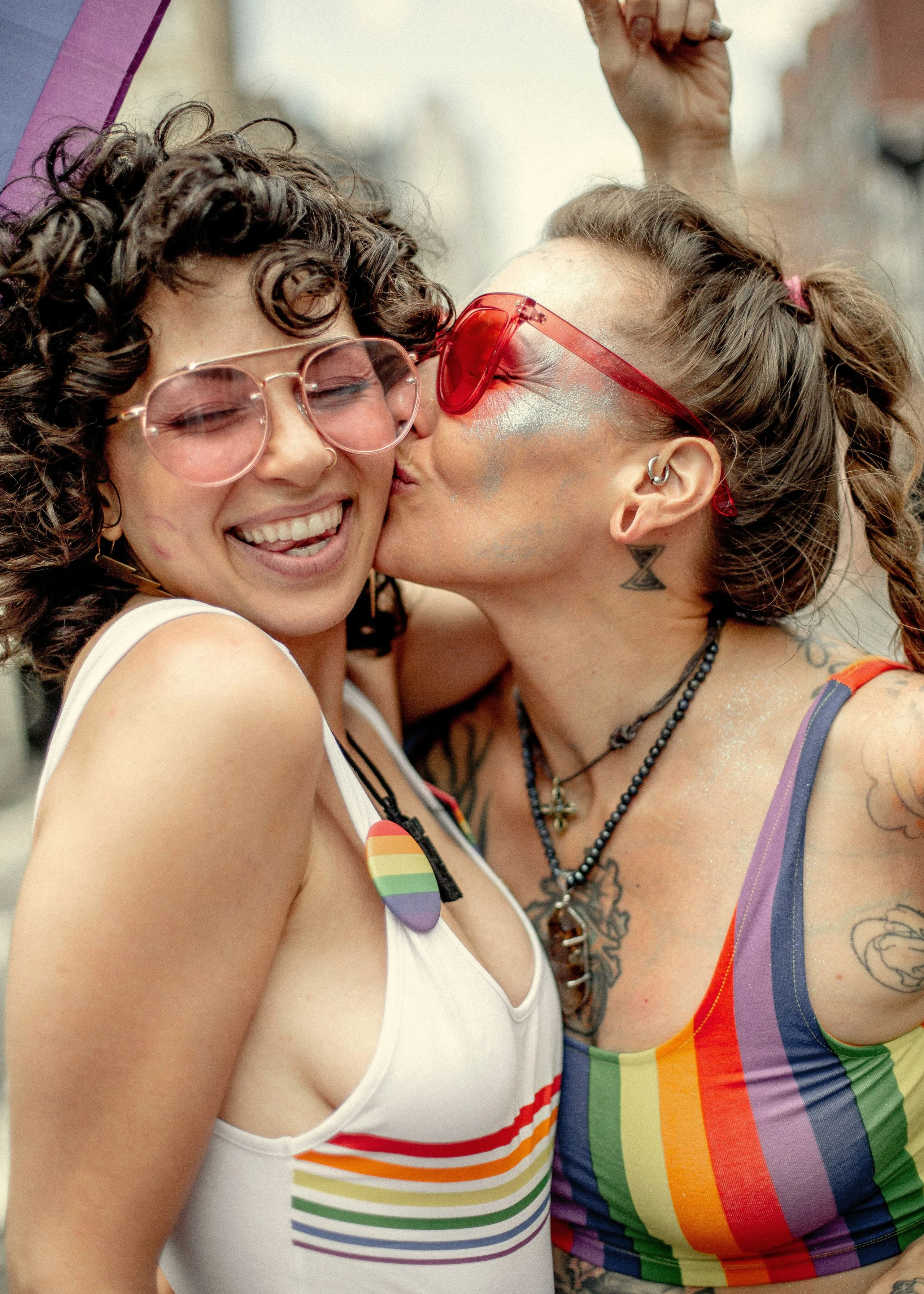 2 Freundinnen, die lachen und Sonnenbrillen aufhaben