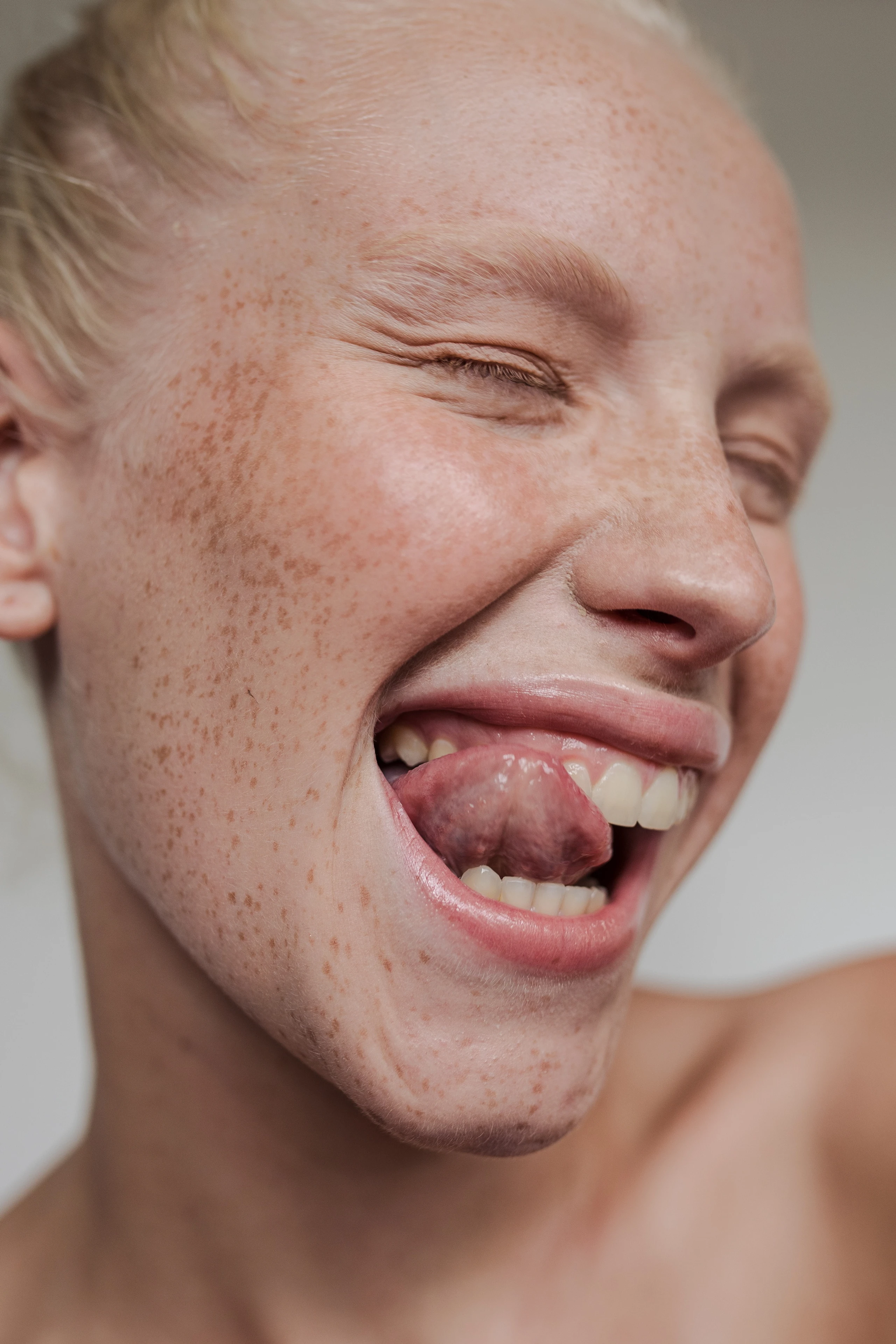 Frau, die sich mit Zunge über Zähne schleckt