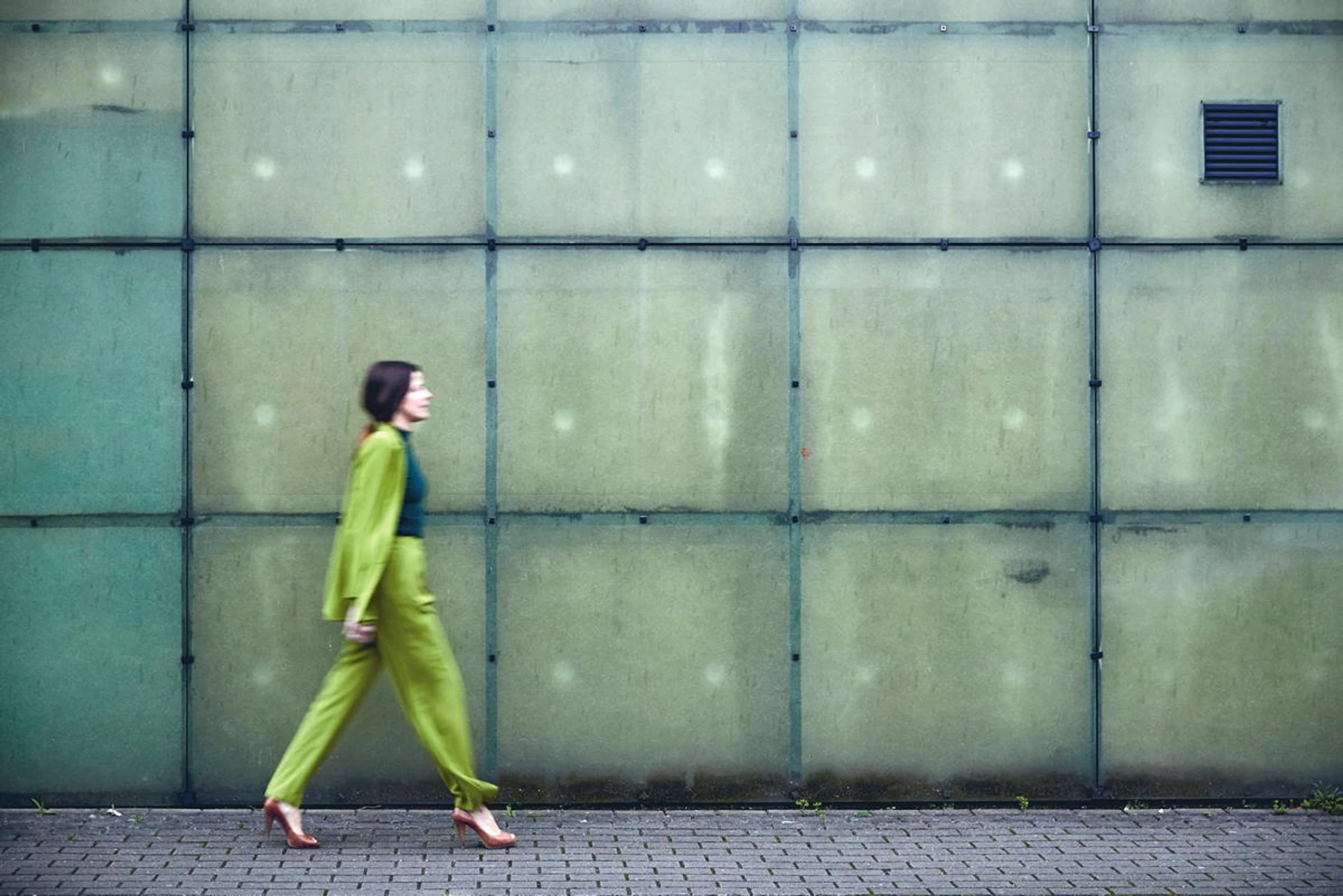 Frau, die vor einer Wand entlang geht