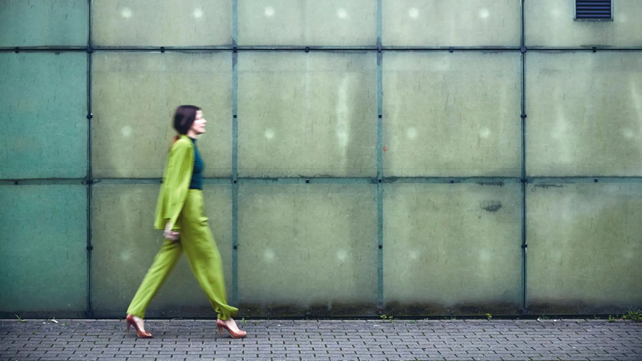 Frau, die vor einer Wand entlang geht