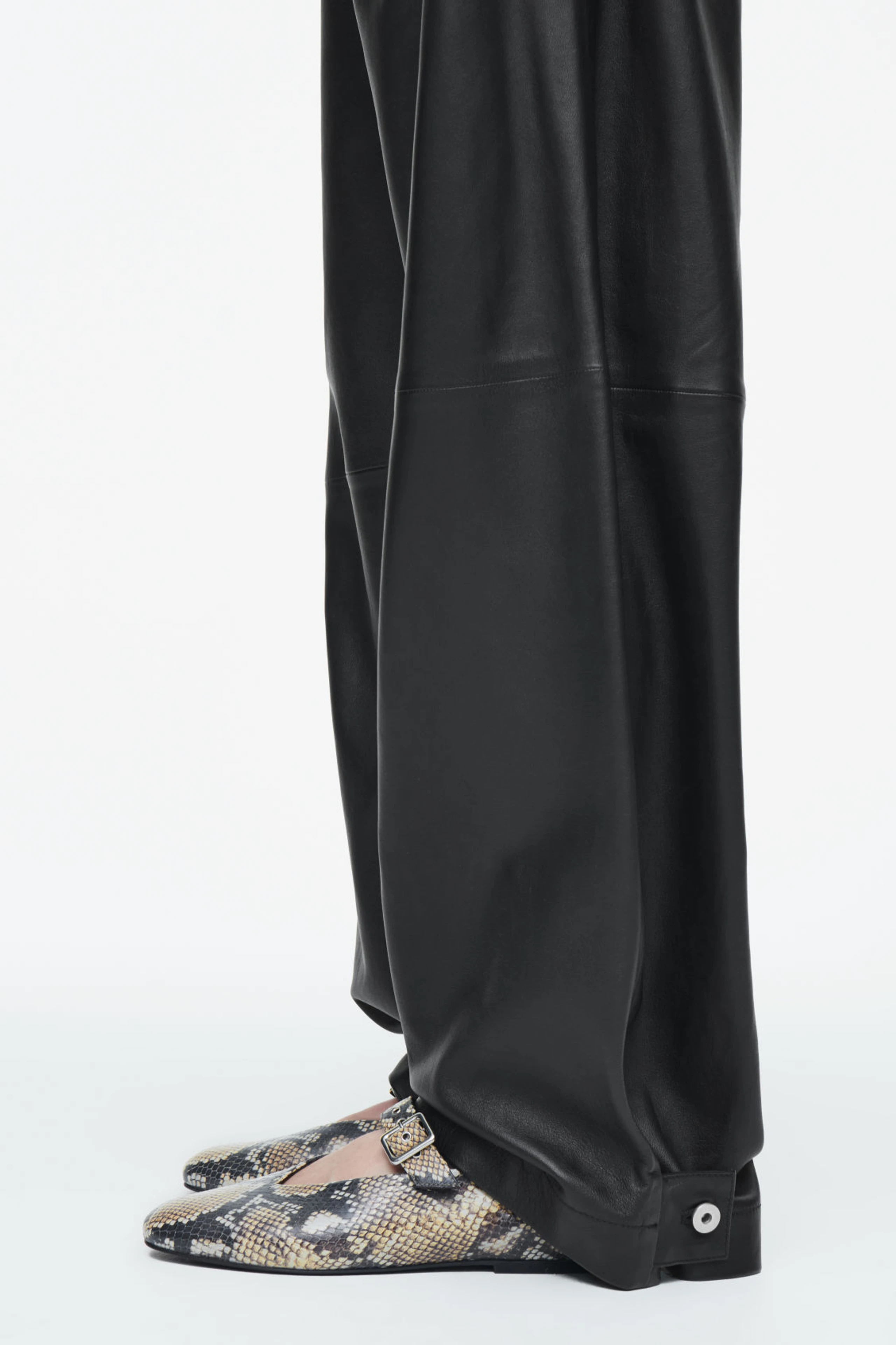 Closeup von schwarzer Hose und Snakeskin-Ballerina