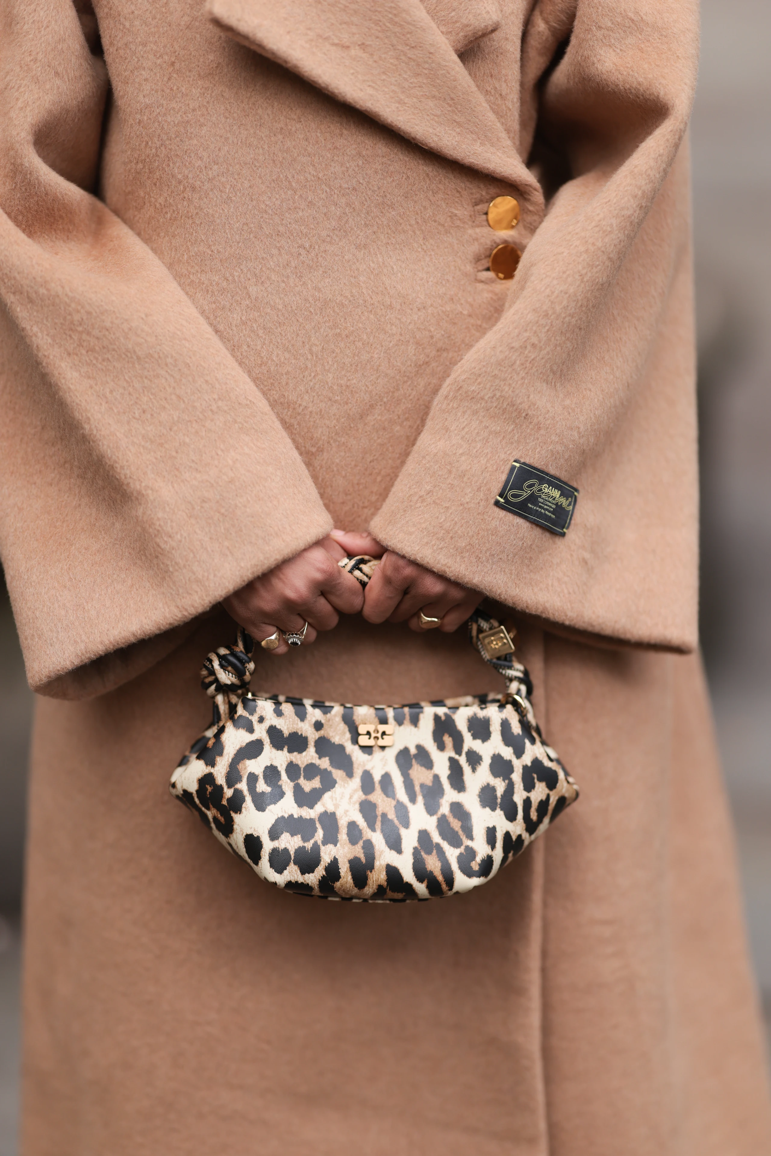 Frau Mit braunem Mantel und Leo-Tasche