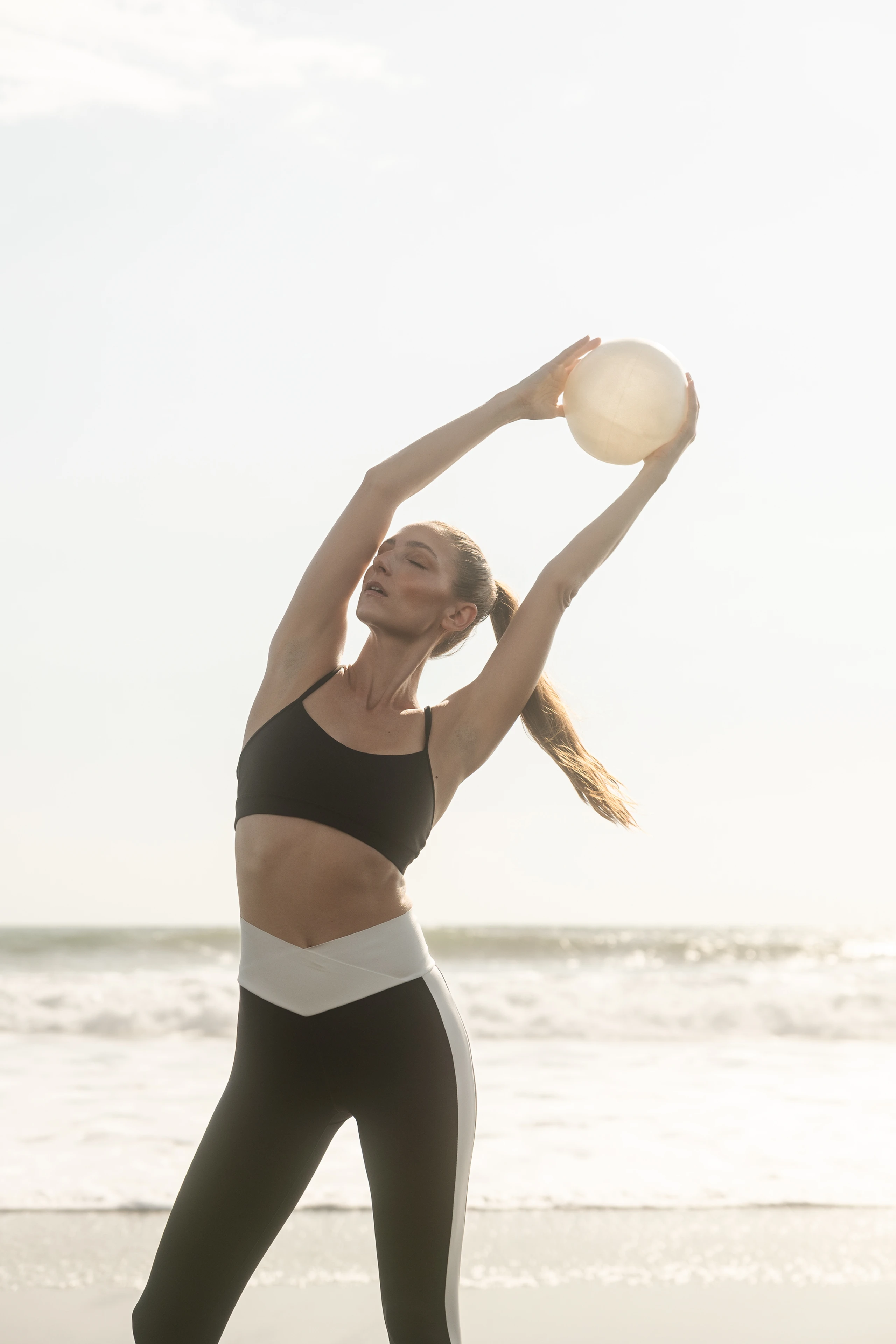 Eine Frau macht Pilates am Strand