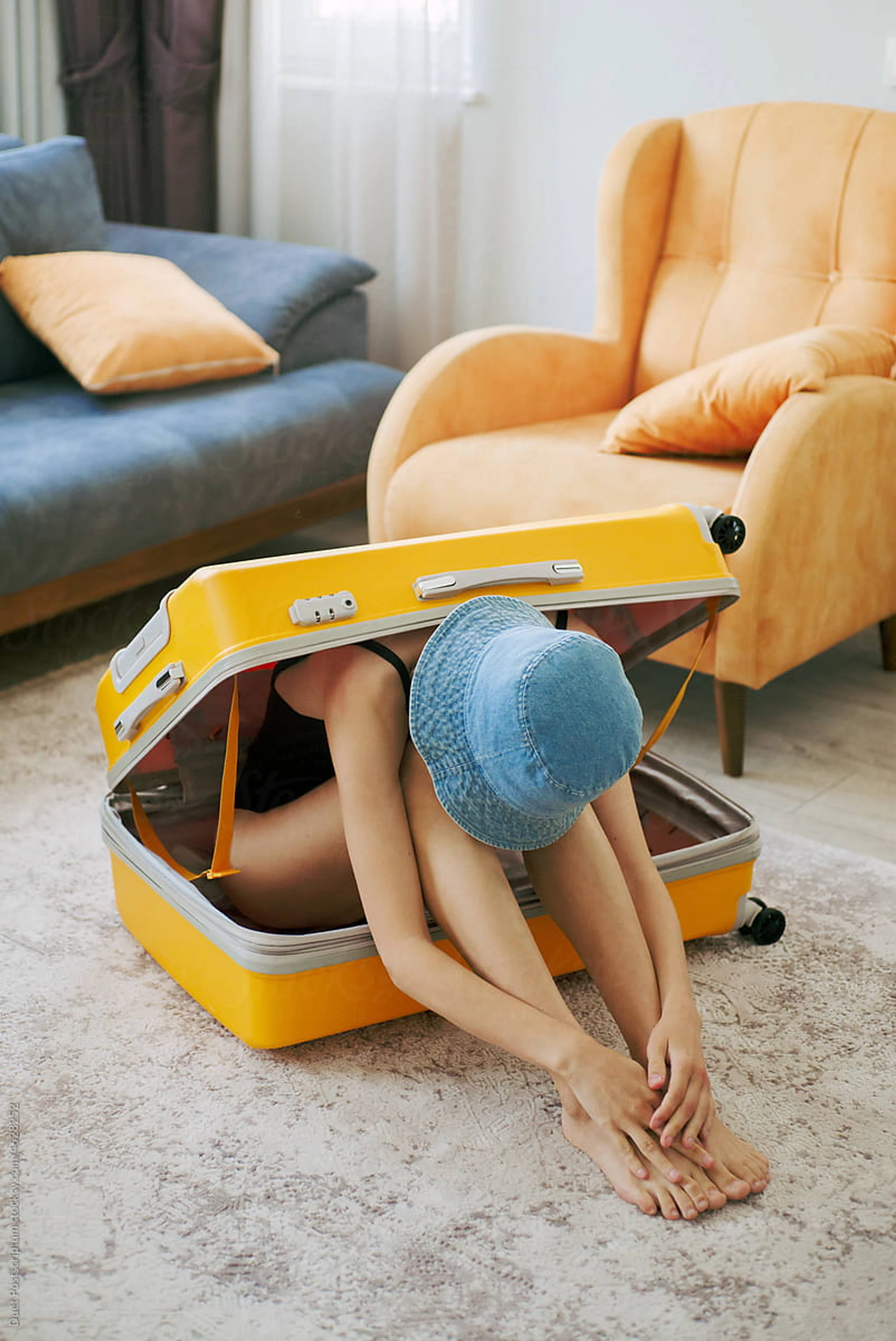 Eine Frau sitzt in einem gelben Koffer