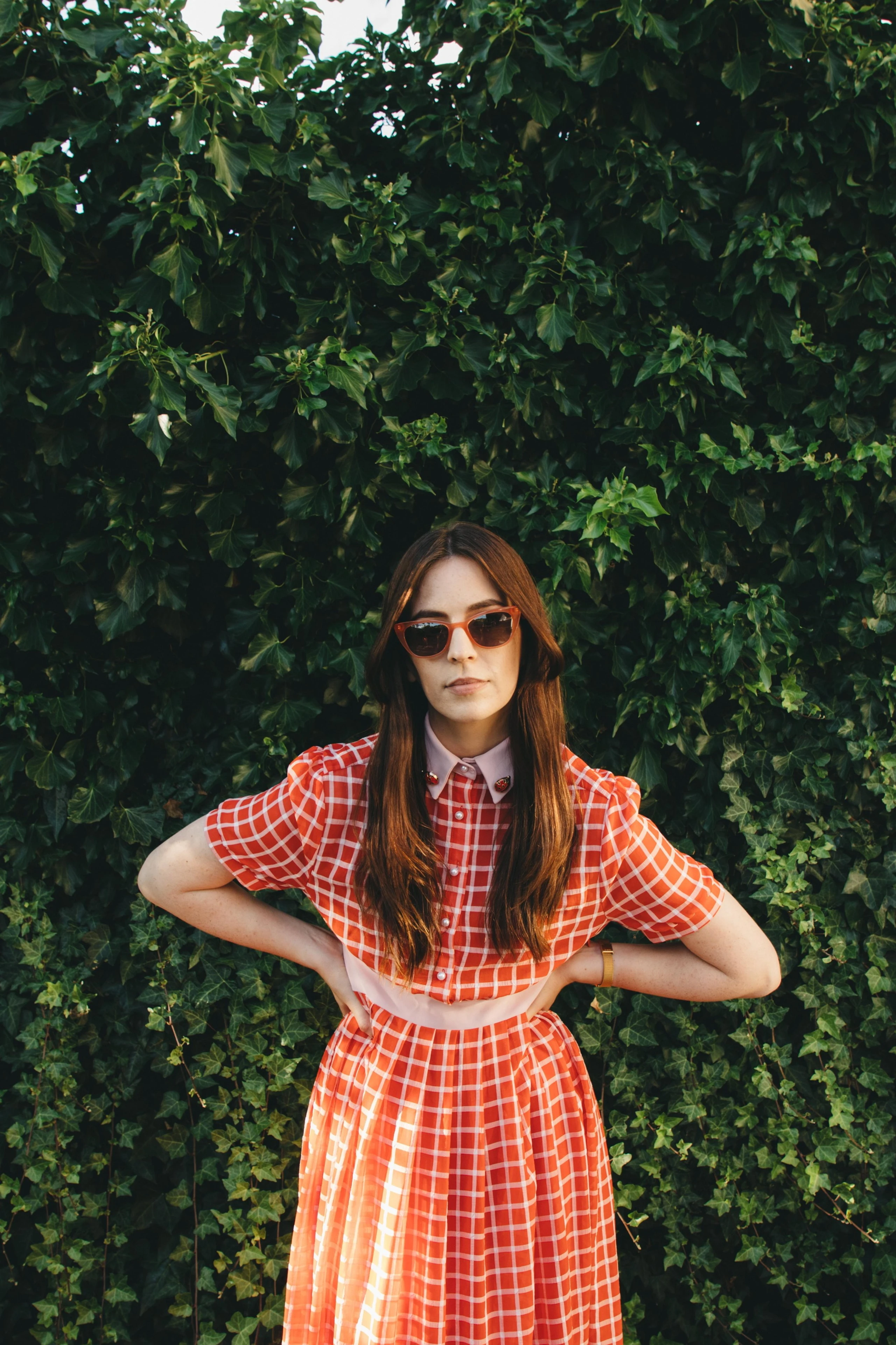 Gemma Styles vor einer hohen Hecke