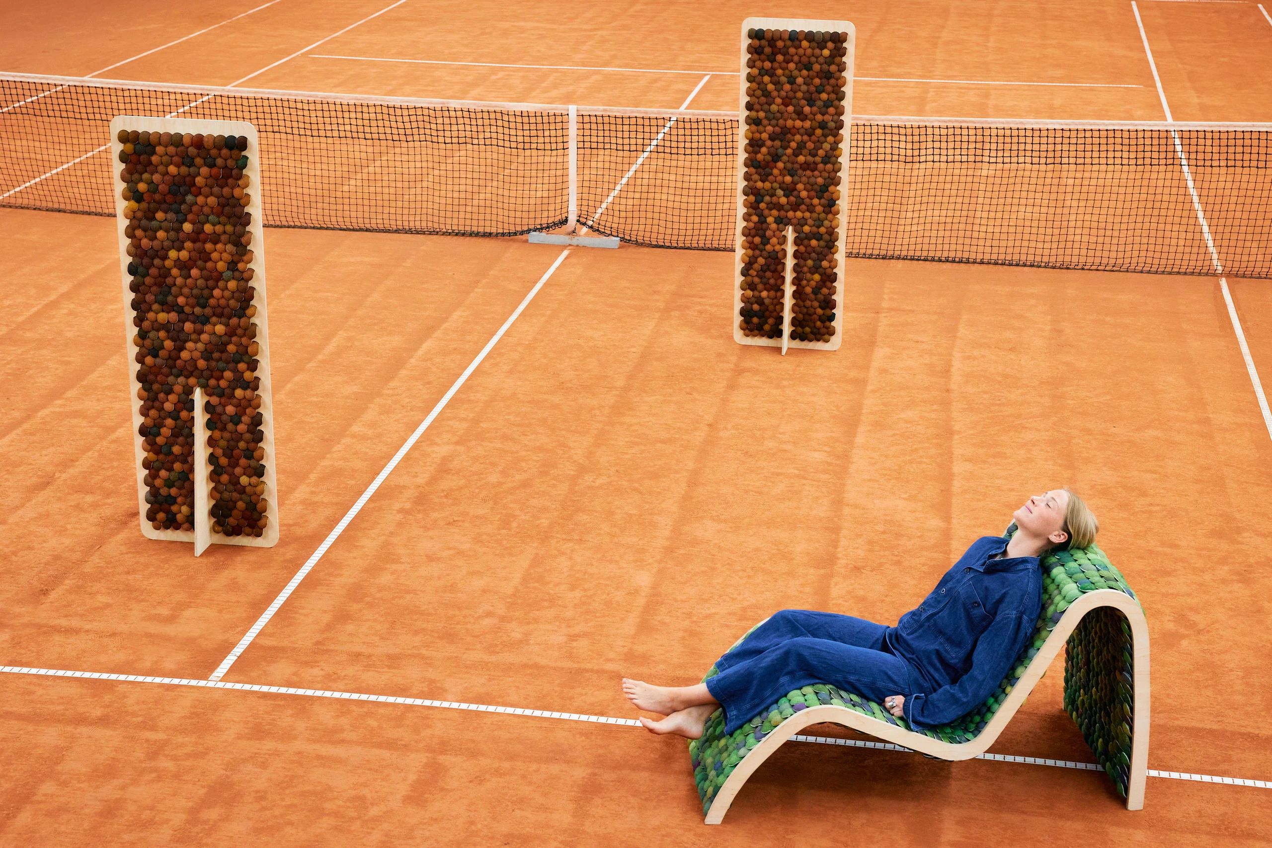 Designerin sitzend auf Loungemöbel aus Tennisbällen