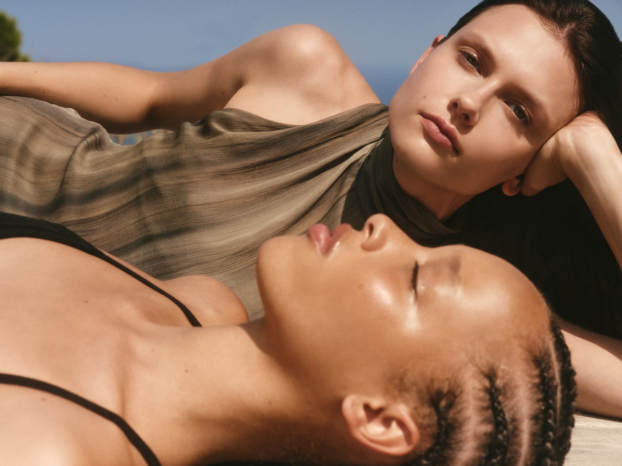 2 Frauen liegen in der Sonne mit strahlender Haut