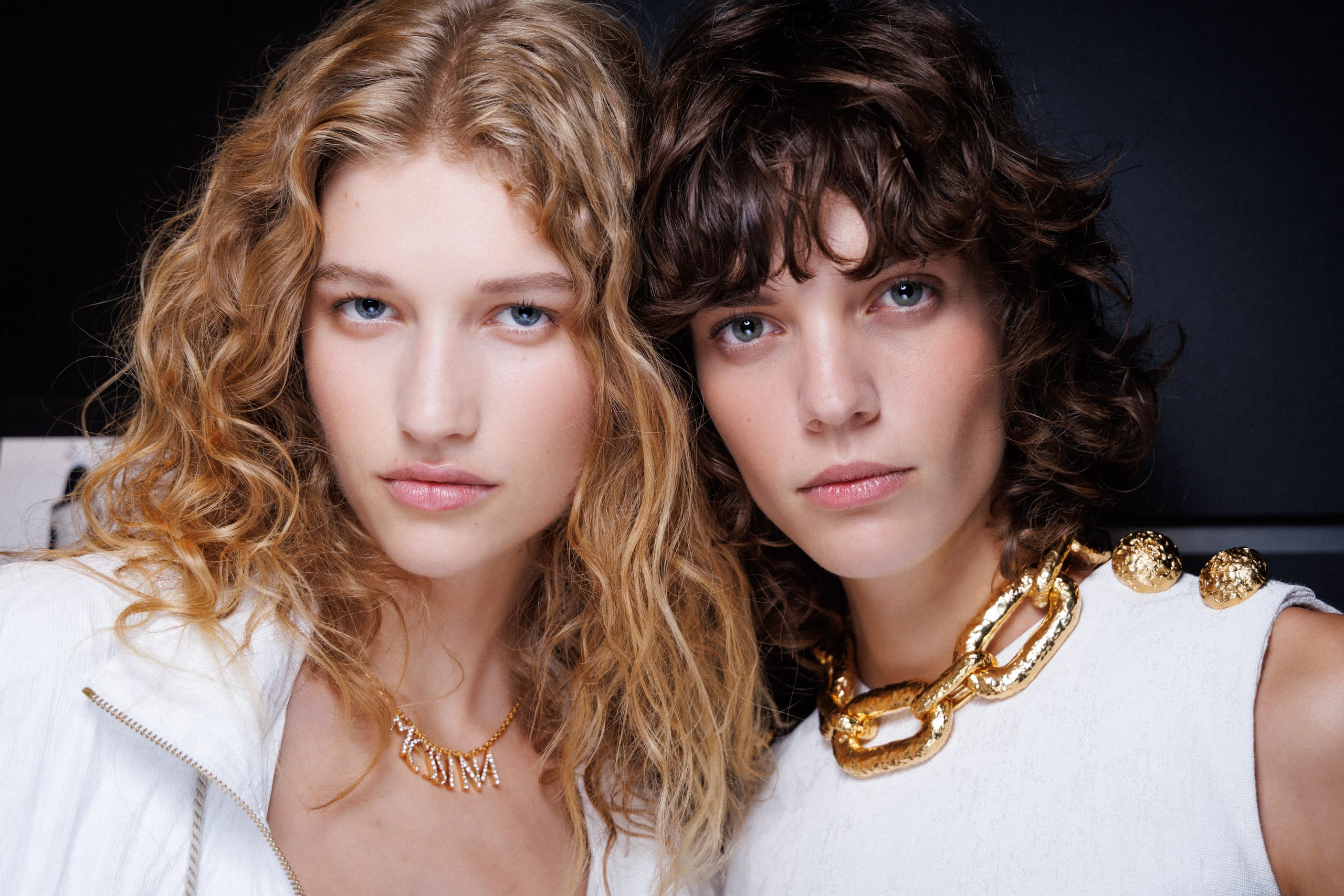 Linkes Model mit langen lockig blonden Haare und rechtes Model mit kürzeren braunen Haaren, beide in weiß gekleidet