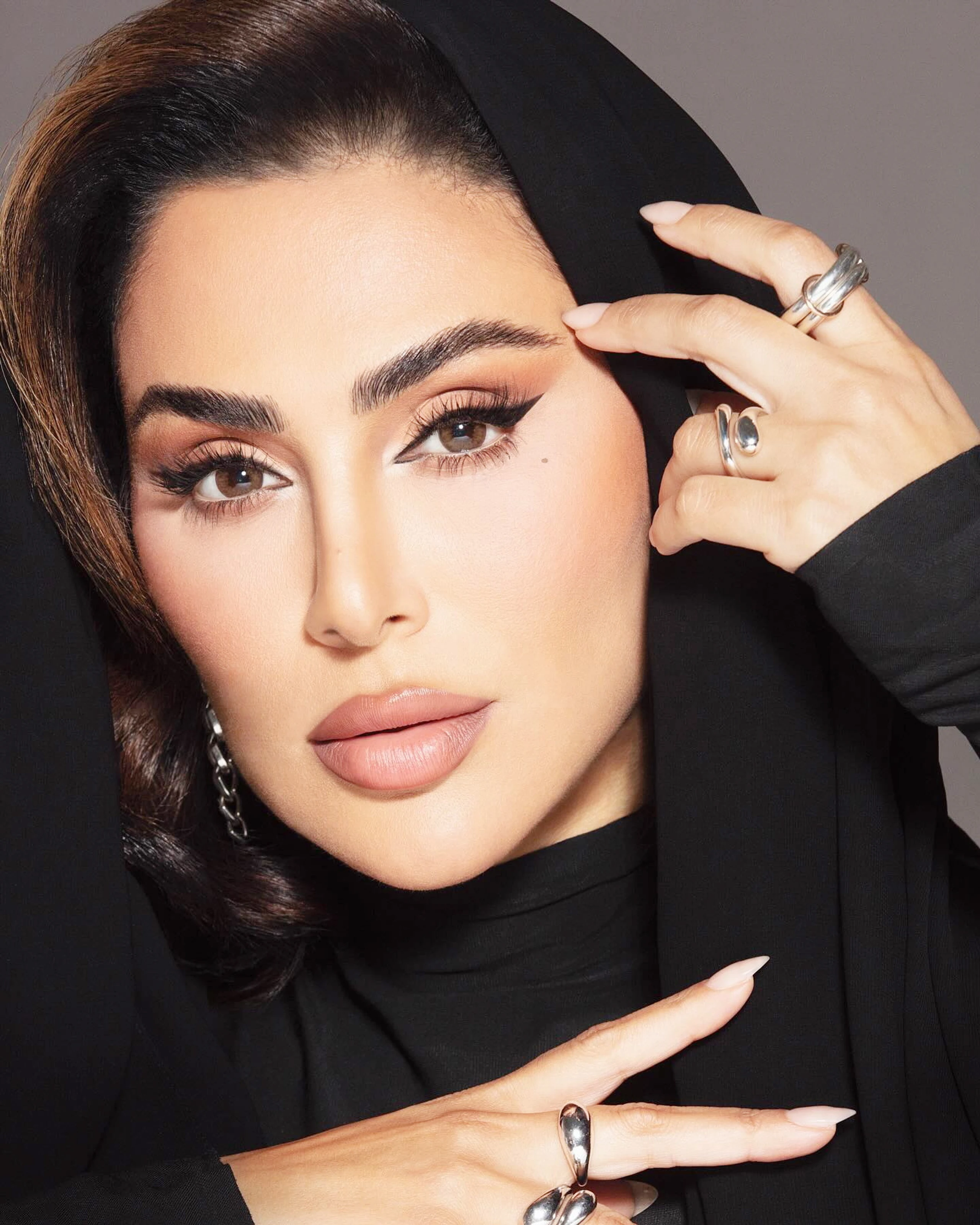 Porträt von Huda Kattan mit ebenmäßig mattem Teint, matten Nude Lippen und großem Eyeliner