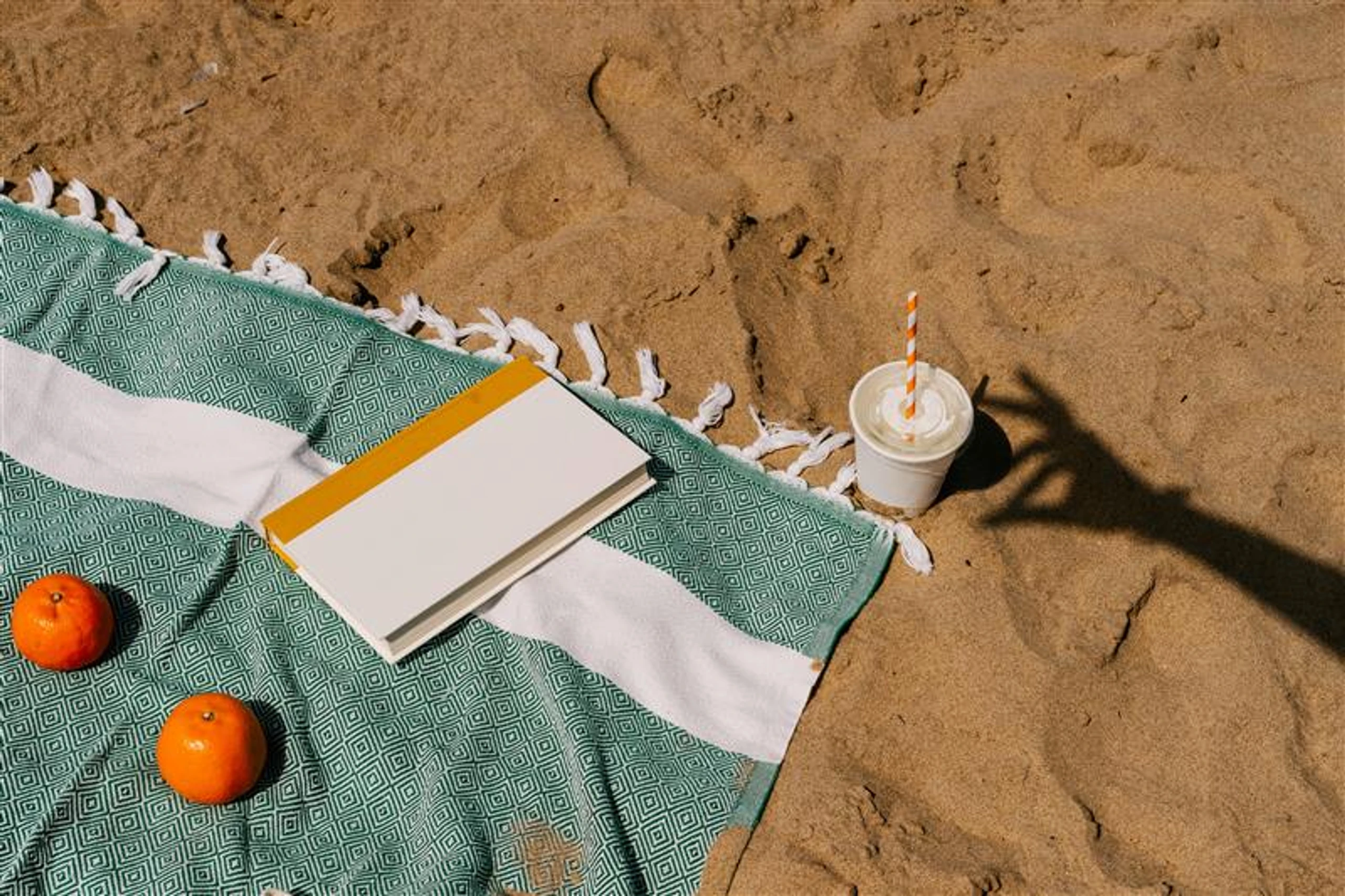 Badetuch mit Buch am Strand