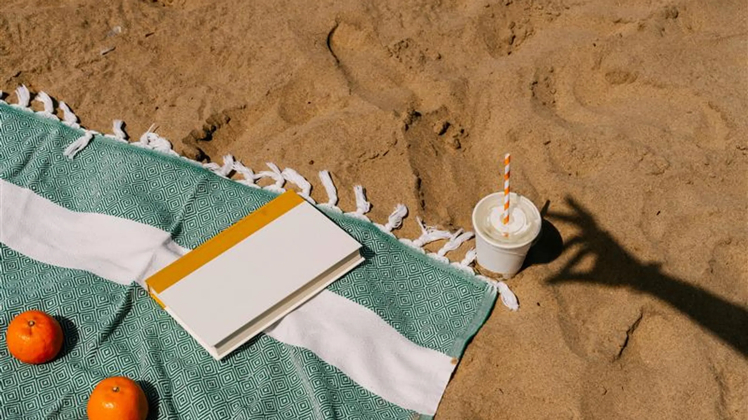Badetuch mit Buch am Strand