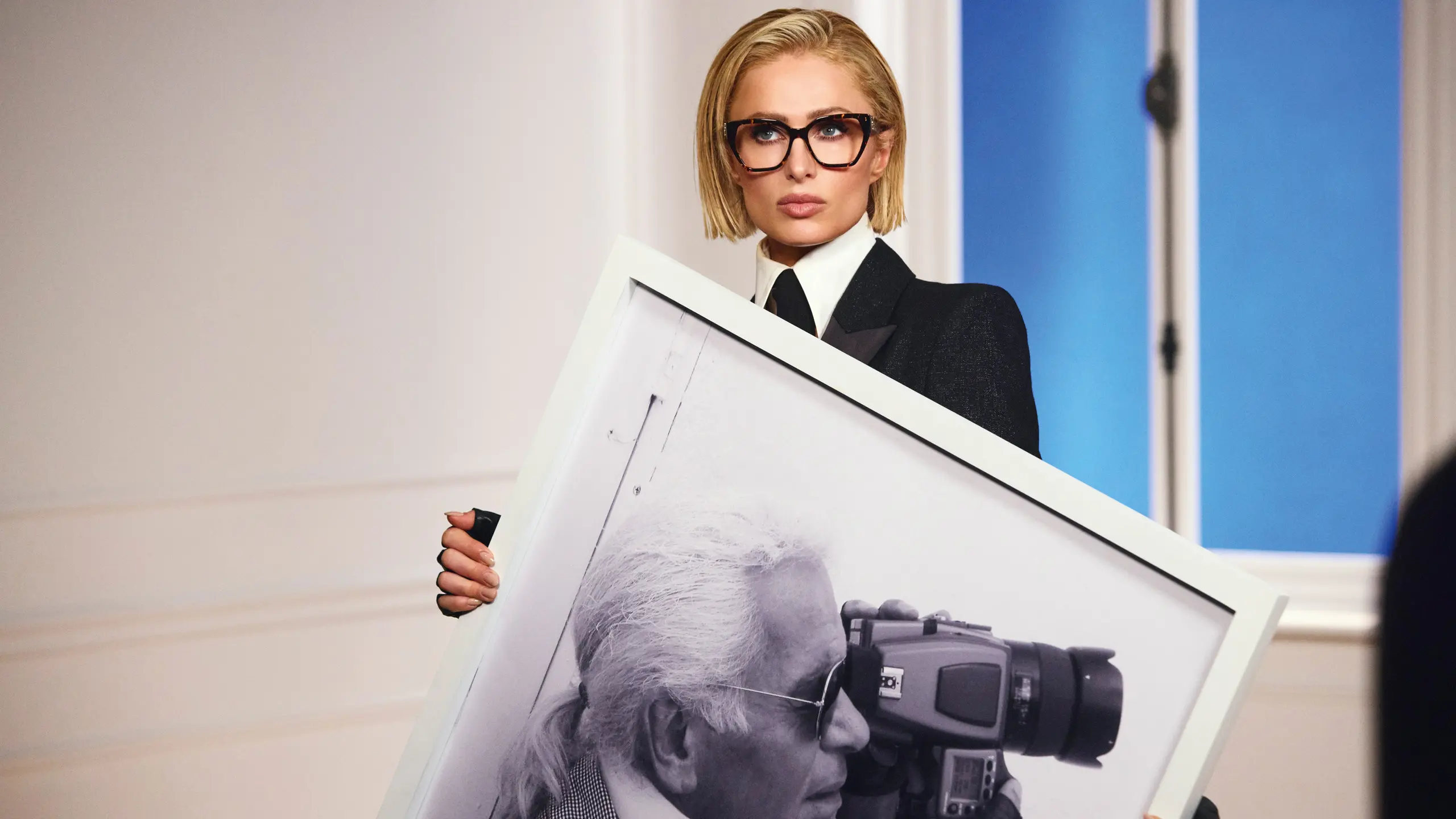 Paris Hilton hält ein großes Schwarz-Weiß.Bild von Karl Lagerfeld wie er gerade fotografiert